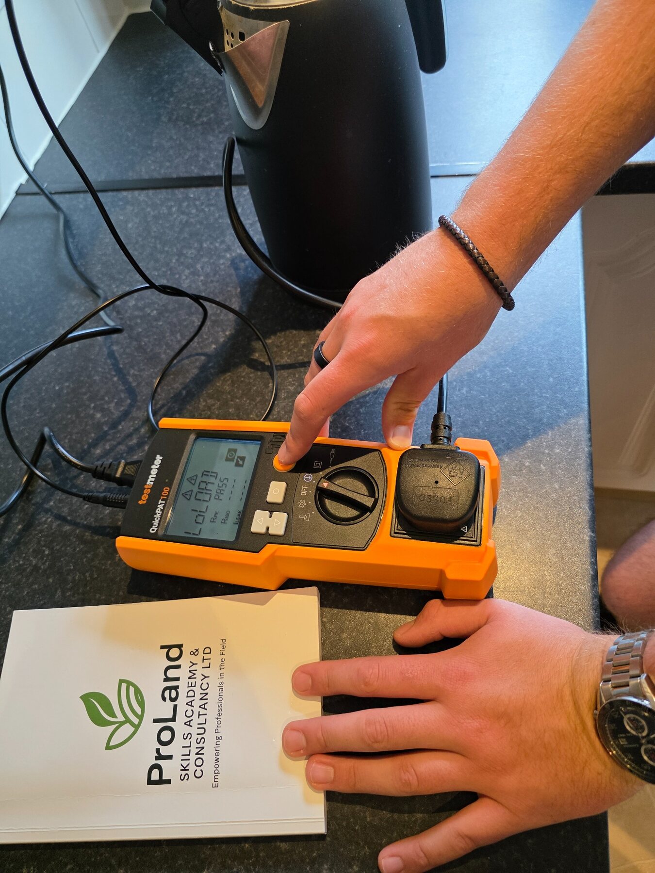 ProLand carrying out a Class 1 appliance test with a QuickPAT tester showing a pass result