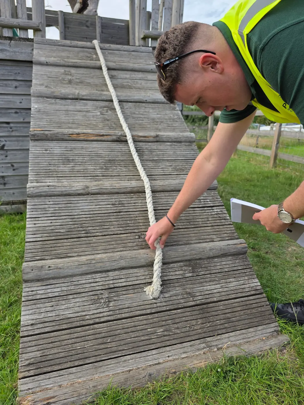 ProLand inspector physically checking a playground climbing rope