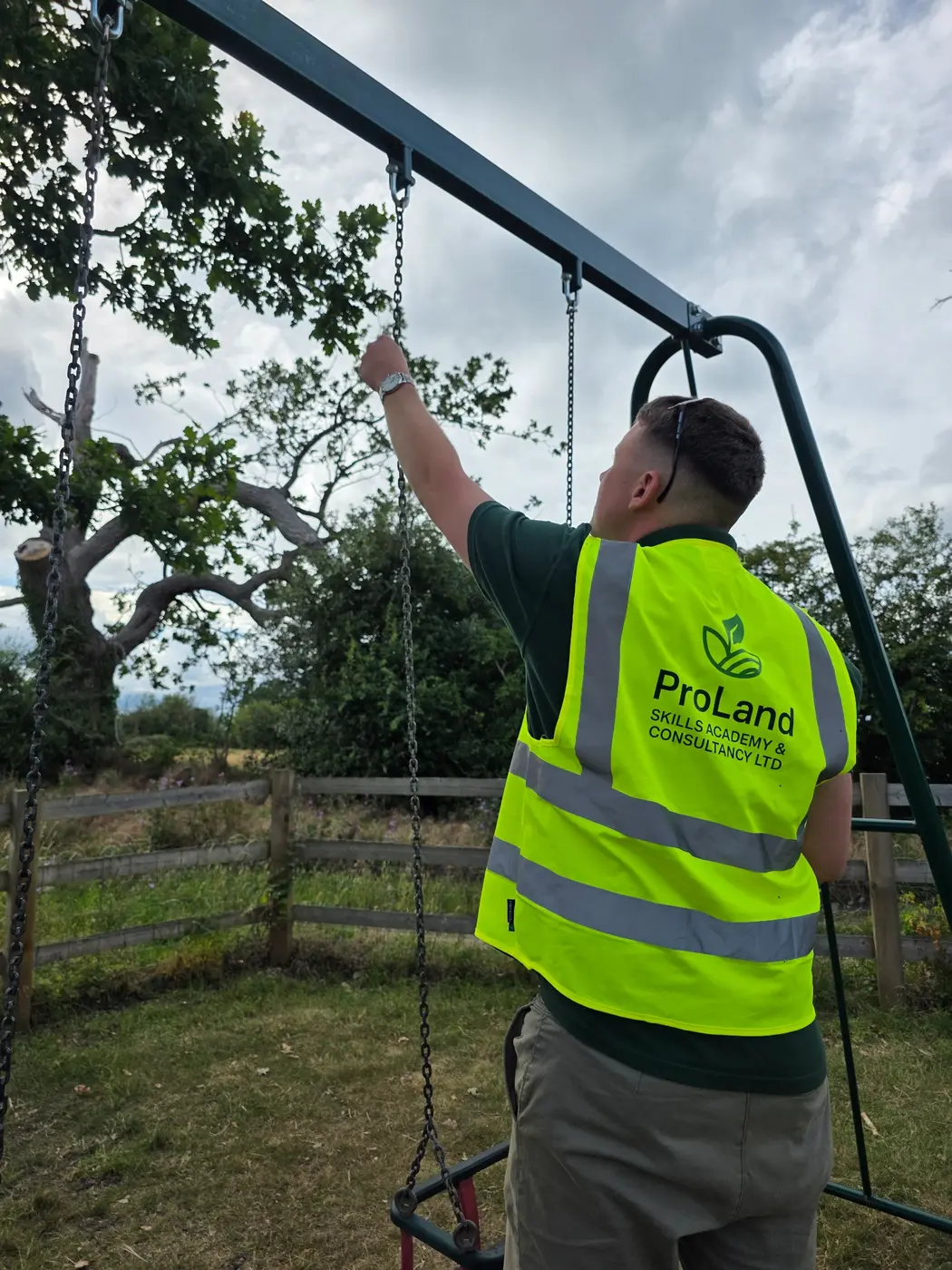 ProLand inspector in high visibility clothing checking playground equipment